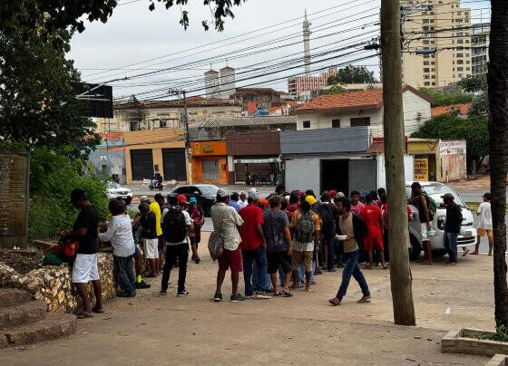 Moradores de rua recebendo marmitas no Morro da Luz.