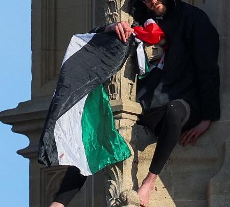 Homem com bandeira da Palestina sentado no topo da torre Big Ben de Londres