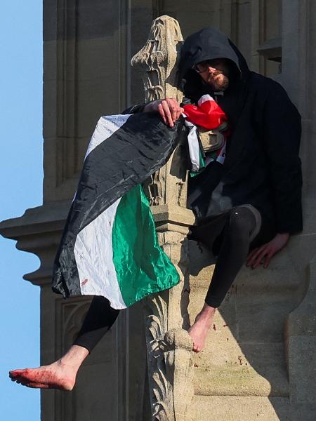 Homem com bandeira da Palestina sentado no topo da torre Big Ben de Londres