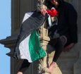 Homem com bandeira da Palestina sentado no topo da torre Big Ben de Londres